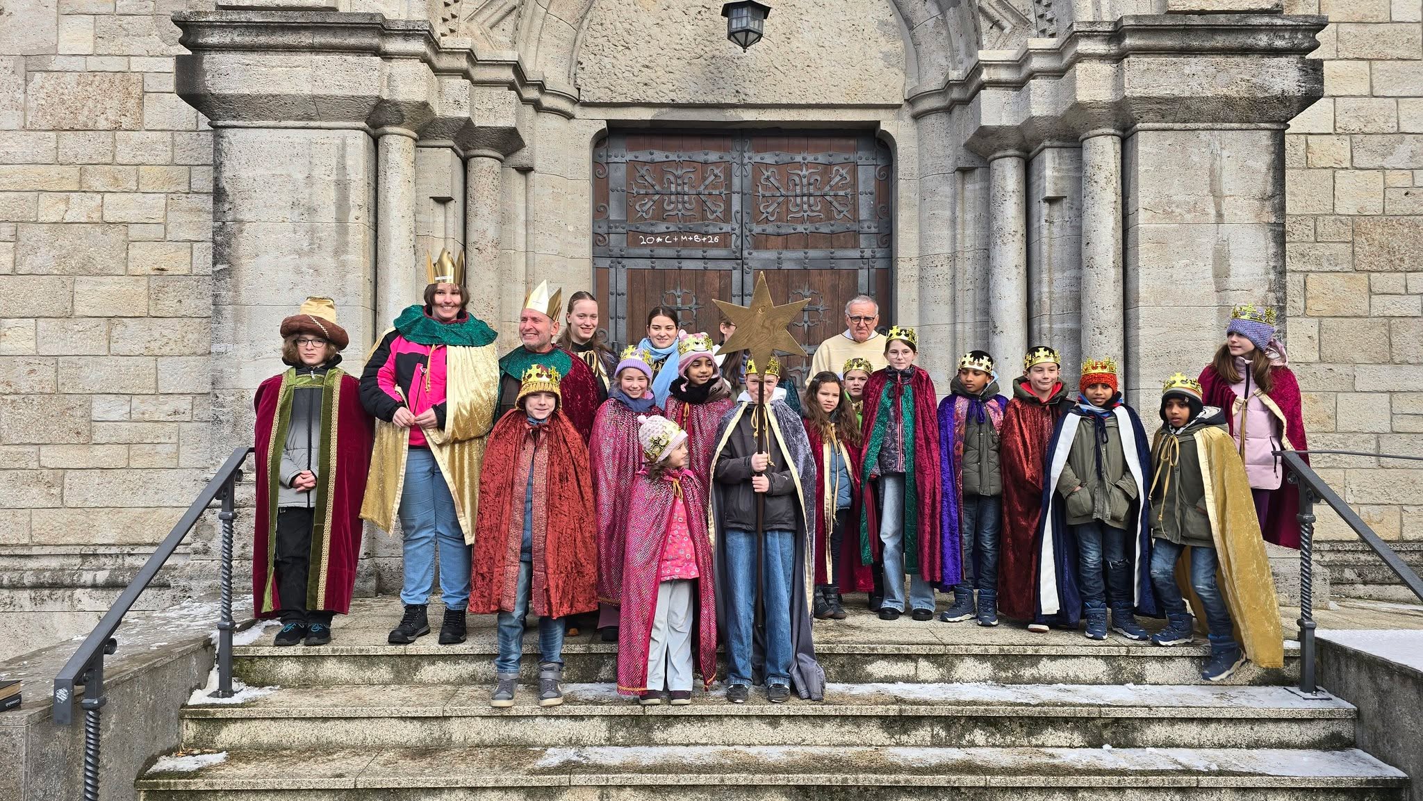 Gruppenbild der Sternsinger vor der St. Adalbero Kirche